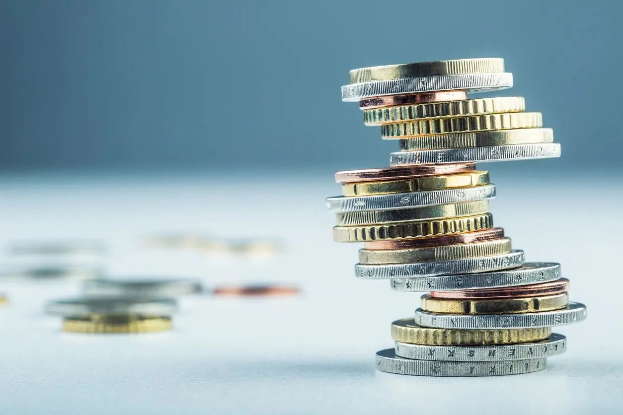 Stack of coins on a light surface with a gray background